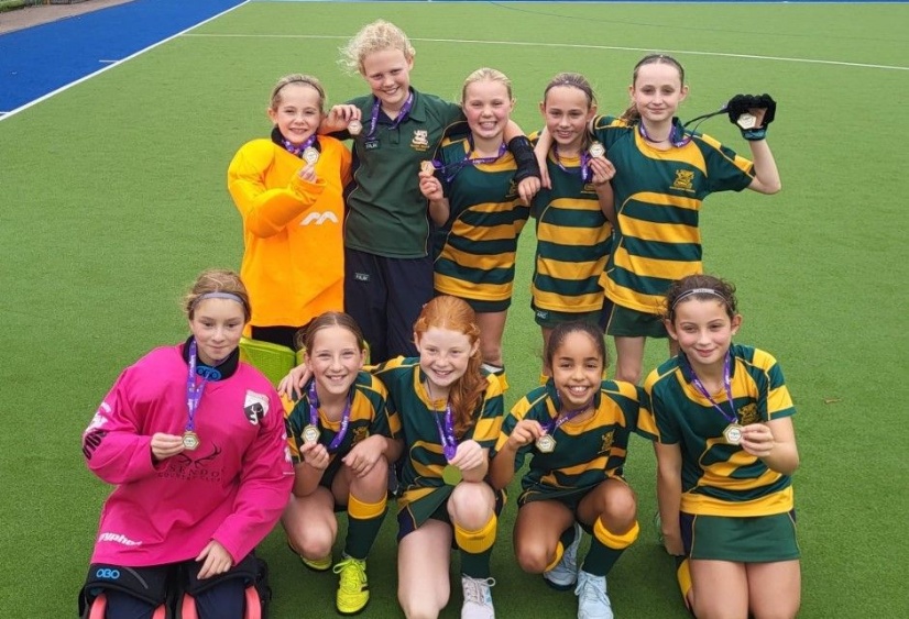 U11 hockey team pose with their gold medals at the U11 IAPS hockey finals